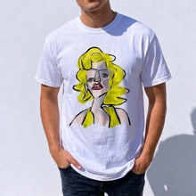 Load image into Gallery viewer, Person wearing a white t-shirt with a graphic design of a woman with yellow hair against a plain background
