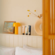 Load image into Gallery viewer, Decorative items on a shelf above a bed with a neutral background