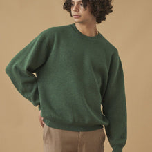 Load image into Gallery viewer, Person wearing a green sweater and brown pants against a beige background