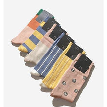 Load image into Gallery viewer, A selection of men's socks in various colors and patterns, displayed in a line, with a brand logo visible on one of the socks.