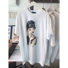 Load image into Gallery viewer, White crew neck t-shirt with a graphic print of a woman's face and hair flipped upwards.