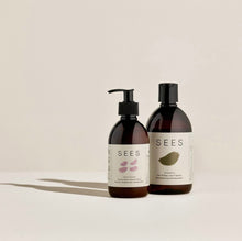 Load image into Gallery viewer, Two bottles of hair care products, one shampoo and one conditioner, with a minimalist design, primarily in brown tones, labeled 'SEES'.